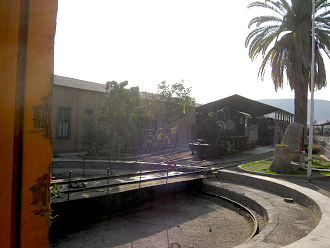 Die kleine Damplokomotive im Bahnhof von
                        Tacna, mit einer Palme daneben