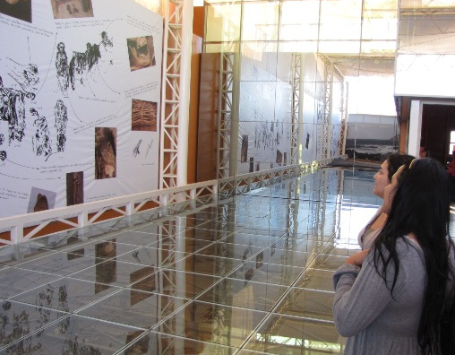 Museo de Sitio Coln 10
                            ("Museo de sitio Coln 10") de
                            Arica, el interior con la vitrina con los
                            muestros de las tumbas de la cultura
                            Chinchorro, y con pinturas en la pared.