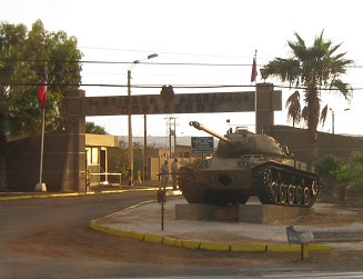Primera brigada, la entrada con un tanque
                        como "adorno", primer plano