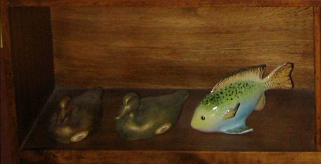 Die Wohnwand der Keramikwerkstatt:
                            bemalte Keramik (Enten und Fisch)