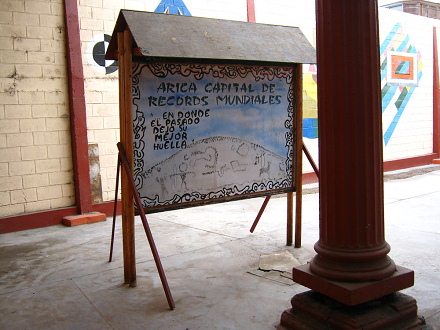 Bild mit der Angabe von
Rekorden von Arica: "Arica, die
Hauptstadt der Weltrekorde" (01) mit
einer Malerei des Heiligen Bergs und seinen
Geoglyphen (cerro Sagrado) und dem Text:
"wo die Vergangenheit ihre beste Spur
hinterlassen hat" Bild mit der Angabe von Rekorden von
Arica: "Arica, die Hauptstadt der
Weltrekorde" (01) mit einer Malerei des
Heiligen Bergs und seinen Geoglyphen (cerro
Sagrado) und dem Text: "wo die
Vergangenheit ihre beste Spur hinterlassen
hat"