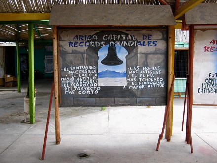 Cuadro indicando r�cords de Arica:
                          "Arica capital de r�cords mundiales"
                          (08) con la campana de un campanario de la
                          Sierra de Arica e indicando el santuario
                          inaccesible, el lago m�s alto, el ferrocarril
                          m�s corto, momias m�s antiguas, un clima m�s
                          templado, y un ferrocarril a mayor altitud