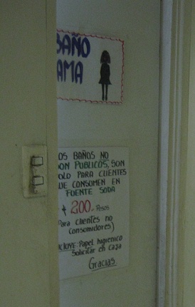 La puerta del ba�o con la indicaci�n como
                        usar el ba�o, con el precio de 200 pesos
                        chilenos