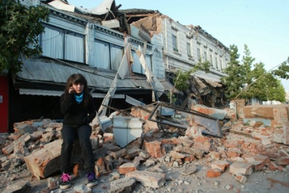 Trmmerstrasse mit Chilenin im Mantel nach dem
                Erdbeben in Chile am 27.2.2010 [33]
