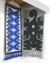 Ecke mit einem grafischen Wandteppich
                            in Blau und einem Fabewesen in Graut�nen