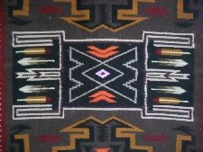 Wandteppich mit grafischem Design mit
                            Pfeilen, Treppen und Romben in der Mitte,
                            das Zentrum mit Pfeilen und Romben