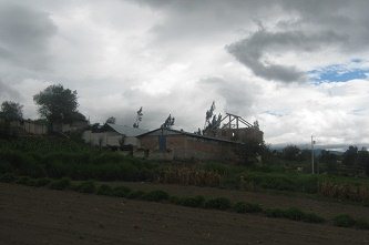 Felder, ein Hof, und viel Wolken