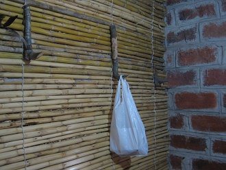 Wandhaken aus Naturholz in einem Ast an
                          der Pfahlrohrwand (span.: carrizo)