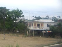 Panamericana in S�d-Ecuador, weisses
                          Stelzenhaus (Pfahlbau) vor Puerto Inca