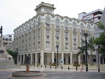 Zentrum von Guayaquil, ein Geb�ude der
                          Stadtverwaltung in Weiss, ein alter
                          Prachtsbau, davor wieder ein Engelsbrunnen,
                          links das Sucre-Denkmal