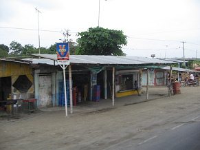 Pasaje de un pueblo ("El
                          Mango"?) con casita de techo ondulado
                          (carretera nacional no. 25)