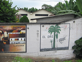 Ortsdurchfahrt vor Machala,
                                    Mauerbild (03), Darstellung des
                                    Goldes der Region: Bananen, Palmen
                                    und Garnelen (Shrimps)