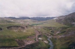 Muro del campo y un arroyo, campos al fondo