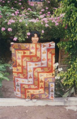 Mrs. Gallardo showing one of her tapestries (span.
            tejido)