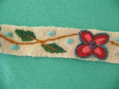 Kunsthandwerk aus Ayacucho:
                  Weisses Band mit roter Blume