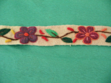 Kunsthandwerk aus Ayacucho:
                  Weisses Band mit violetter Blume