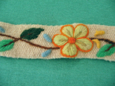 Kunsthandwerk aus Ayacucho:
                  Weisses Band mit gelber Blume