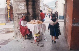Plaza de Armas: A woman indgena selling
                        pastry on a table