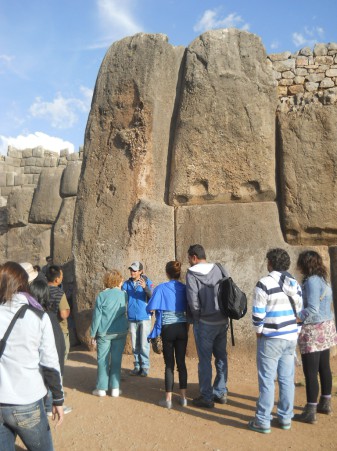 Cusco Sacsayhuamn, giant corner stone of the zigzag wall with tourists