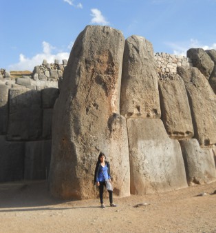 Cusco Sacsayhuam�n, giant corner stone of the zigzag wall with tourists - with an adult person