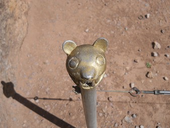 Palo en metal con la figura de una cara de un felino, zoom