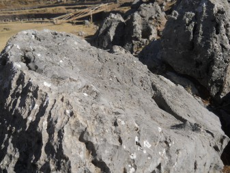 Cusco Sacsayhuamn 10, Chaosbereich: Noch ein geschmolzener Stein mit Lchern und Thronen - grob gefrste Oberflche