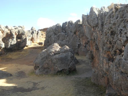 Cusco Sacsayhuam�n, even more mysteries: rock walls of the corridor in black and red with niches and thrones 8