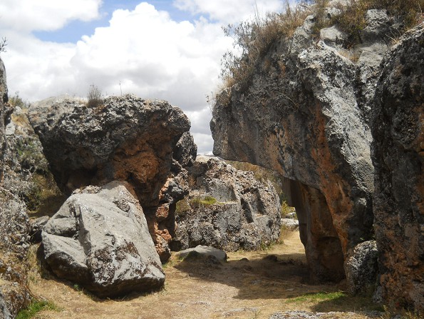 Cusco Sacsayhuamn, Zone X (Laq'o, Laco, Mondtempel), der umgedrehte rot-schwarze Felsen mit dem umgedrehten Thron (rechts) und der schwarze Felsen mit den Thronen (im Hintergrund)