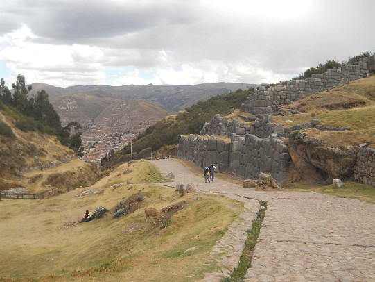 Cusco Sacsayhuamn 16: Der Weg zurck nach Cusco, Strasse mit Zickzackmauer im Hintergrund 01