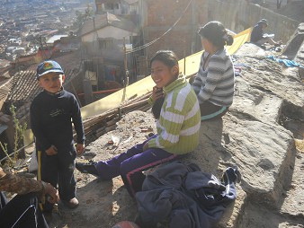 Cusco Sacsayhuam�n 16: El camino regreso a Cusco, poblaci�n de Cusco sentando en el banco de piedra cortada