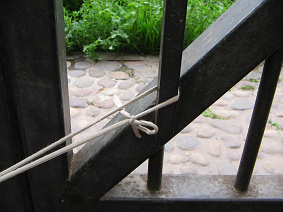 Das andere Ende des
                          Taillen-Webstuhls ist hier am Pfosten
                          befestigt