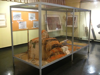 Vitrine mit Webereien mit Federn