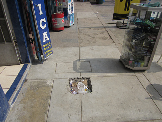 Hueco en la acera de la avenida Tupac Am�ru
                        que ya est� lleno con basura