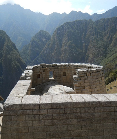 Machu Picchu, vista al templo del sol
                    por arriba con una piedra gigante y con el panorama
                    de monta�as