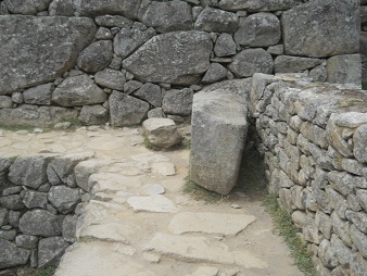 Machu Picchu al lado izquierdo de la plaza
                    central, camino con muro