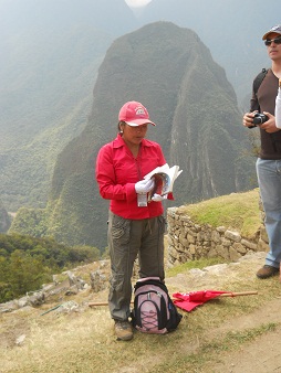 Eine Reiseleiterin auf Machu Picchu mit dem Putucusi-Berg im Hintergrund (die Reisef�hrer kleiden sich immer in Rot, um besser sichtbar zu sein)