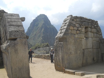 Machu Picchu: Der Hausberg Huaynapicchu
                    zwischen der rechten Mauer des Haupttempels und der
                    linken Mauer des Tempels zu den 3 Fenstern