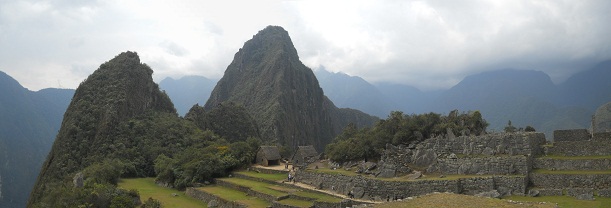 Machu Picchu: Sicht von der Sonnenpyramide auf
                    die beiden Hausberge Huchuypicchu und Huaynapicchu
                    mit der Silhouette eines Adlers, der die Fl�gel
                    anhebt - Panoramafoto 02