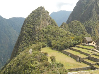 Machu Picchu: Sicht von der Sonnenpyramide auf
                    den kleinen Hausberg Huchuypicchu mit Sonnenschein