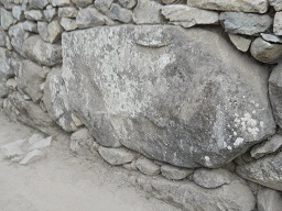 Zwischen dem Weiler mit dem heiligen Stein und
                    den Arbeitshusern: Ein grosser Stein in der Mauer