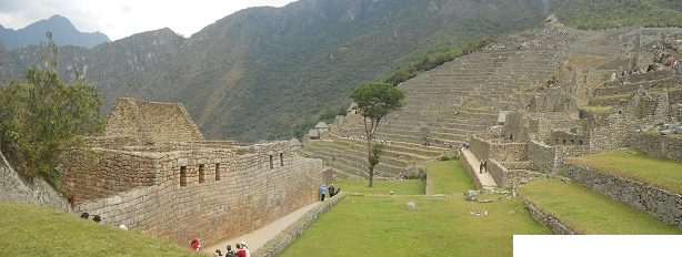 Machu Picchu: Sicht
                        von der oberen Plattform auf die grosse Mauer
                        mit dem Zentralplatz, dem Baum und dem
                        Landwirtschaftssektor
