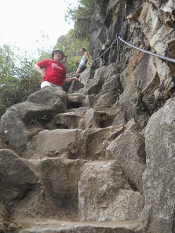 Wanderweg zum Hausberg Huaynapicchu,
                    unregelmssige Treppe mit Seil, Sicht nach oben mit
                    Touristen