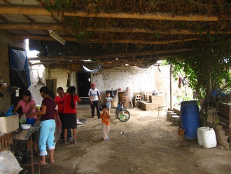 La familia est� cocinando, al lado
                            bidones y el barril de agua