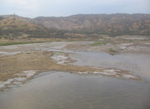 Panamericana Norte en el norte del Per
                        cerca de Mncora, travesa de un ro con cerros
                        del desierto al fondo