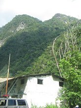 Weisses Haus mit Urwaldbergen im Hintergrund