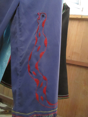 Blaue Hose mit gestickter Anaconda mit roten
                Flecken (Shipibo-Kulturhaus in Yarina, Region Pucallpa)
                - Nahaufnahme