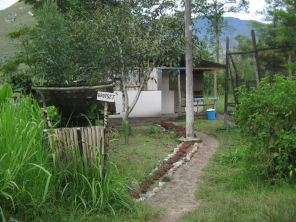 Casa con cubo de basura y la placa
                          "Rrotset" (yanesha: cubo de basura)