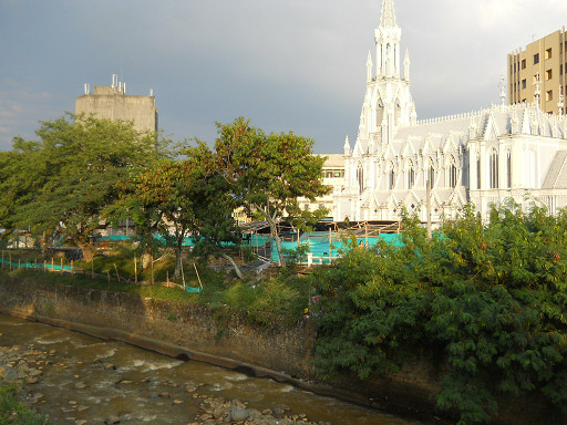 Kirche von Cali mit Fluss und
                modernen Sparbauten nebendran